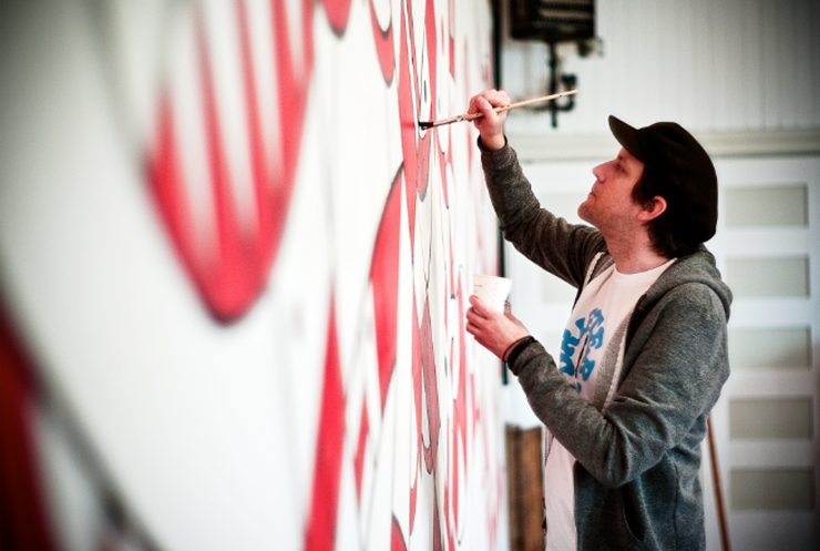 El artista Don Pendelton trabajando en un mural