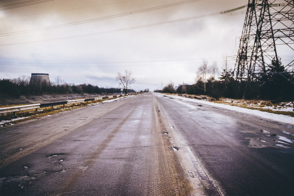 A la derecha la torre de enfriamiento para la quinta unidad de la central nuclear de Chernobyl, carretera que llega sarcófago.